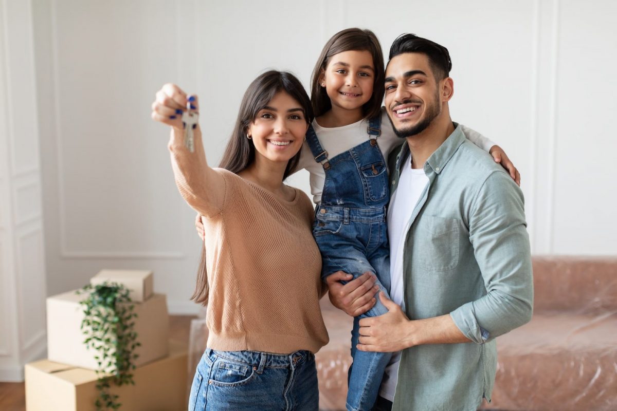 Happy young family showing keys of their apartment